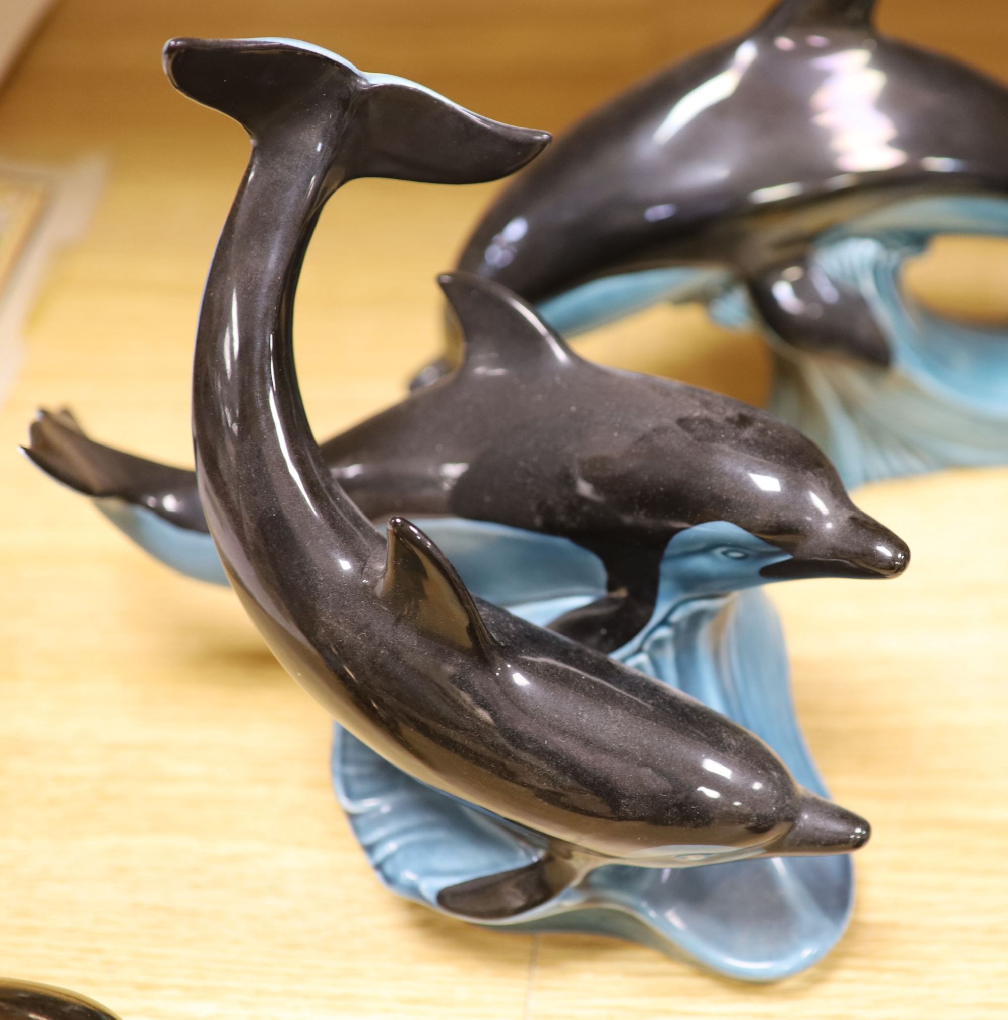 Six Poole pottery dolphins together with two similar seals and an otter